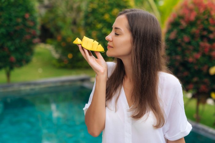 woman happily eating mango