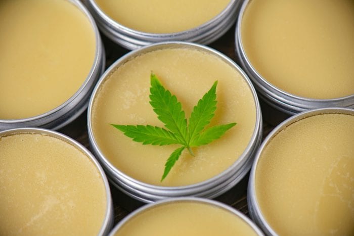 Close up of jars of cannabis topicals salve with cannabis leaf on top