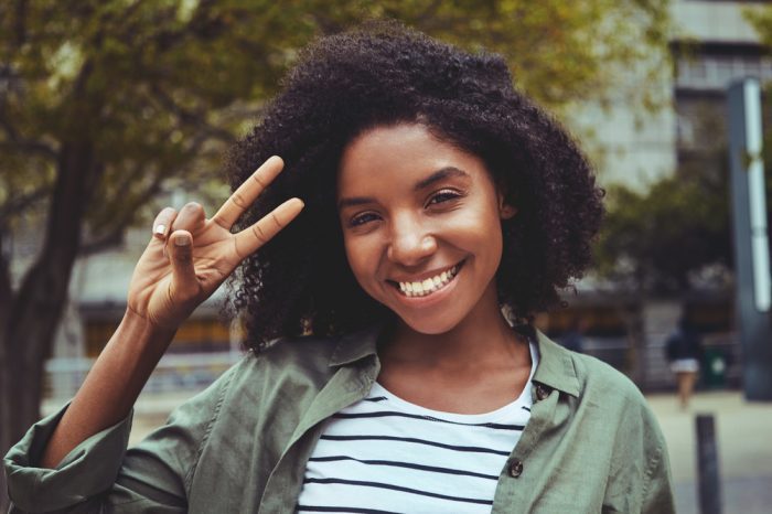 smart looking girl giving peace sign