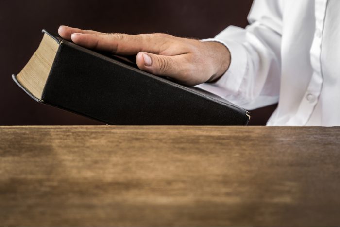 hippocratic oath of do no harm represented by doctor with hand on book
