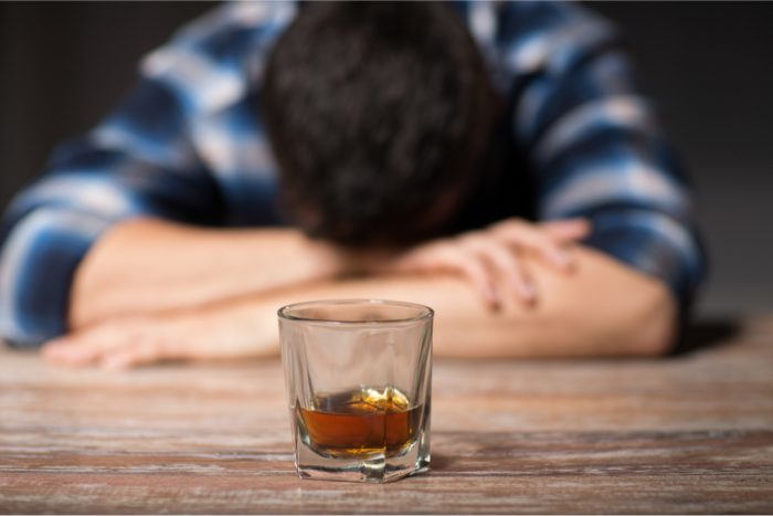 alcoholic man sitting at table