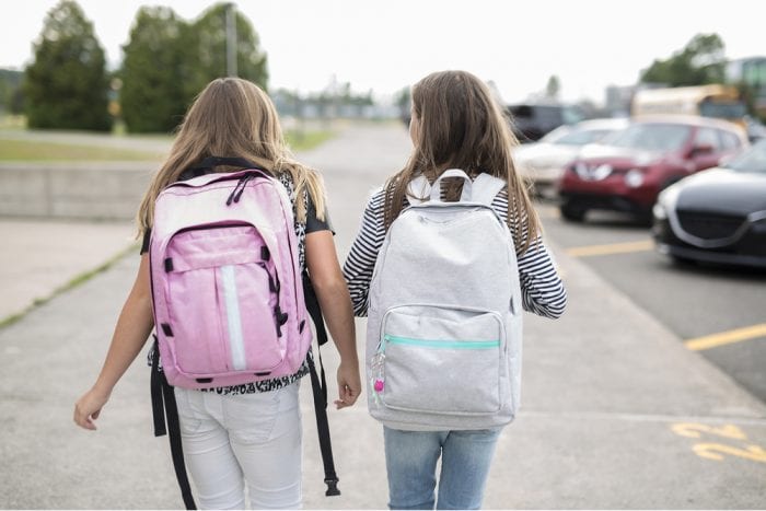 2 girls walking with backpacks on