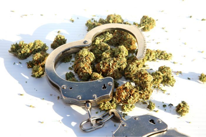 cannabis pardons represented by handcuffs and cannabis bud