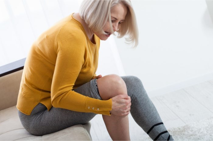 chronic non cancer pain represented by woman holding her knee