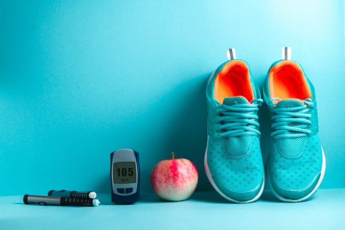 a blood sugar tester, apple, and shoes, 